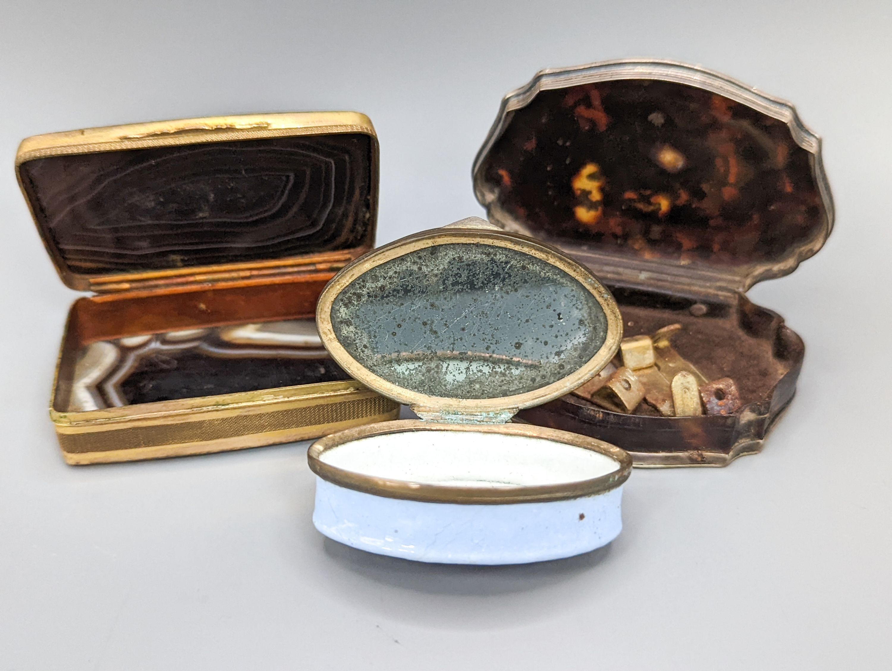 An 18th century silver inlaid tortoiseshell cartouche shaped snuff box, 7.4cm, an agate snuff box and Staffordshire enamel box (3)